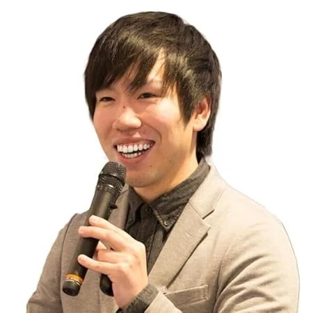 笑顔でマイクを握るアジア人男性