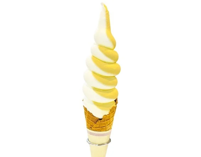 白と黄色の二色で高く巻かれたソフトクリーム