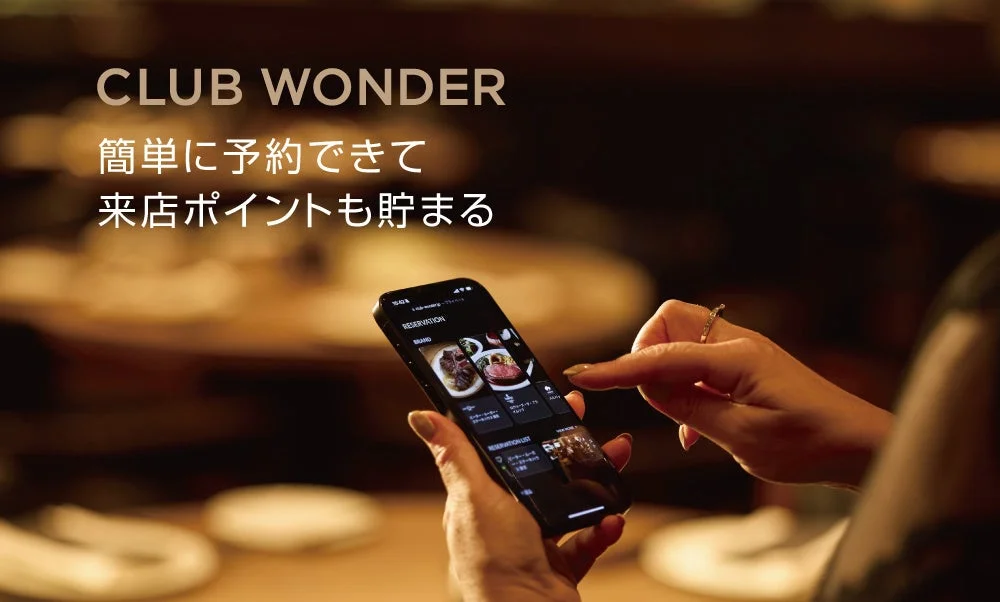 スマートフォンでClub Wonderアプリを操作する女性