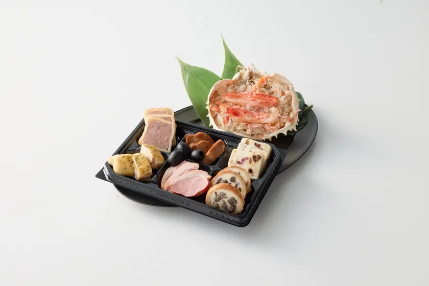 パテ、スモークダック、チーズ、オリーブなどの洋風料理と、甲羅に盛られたカニ肉のオードブルセット