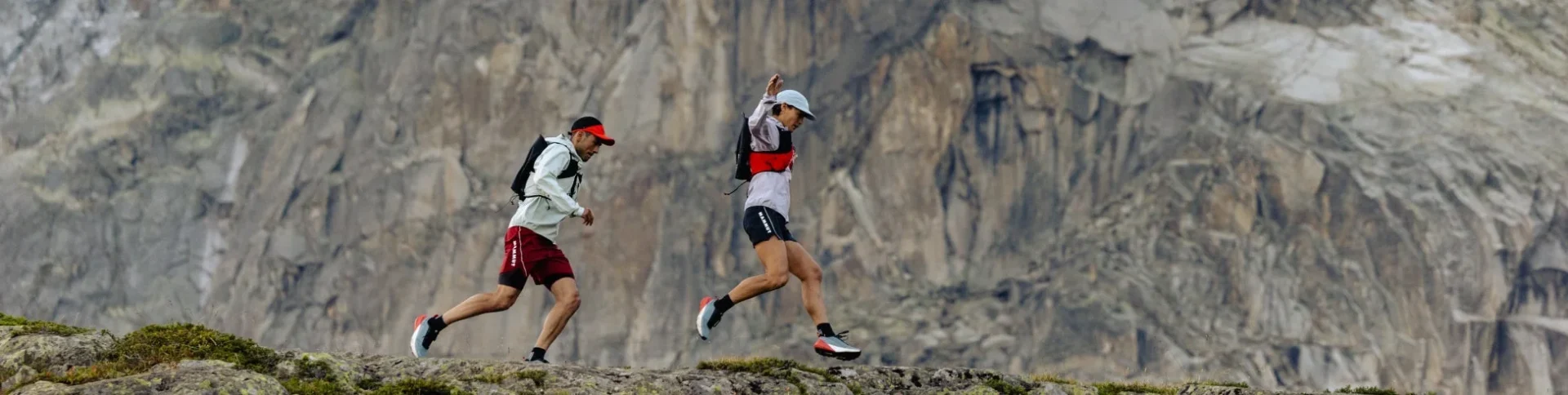 岩場の山道をトレイルランニングする2人の姿