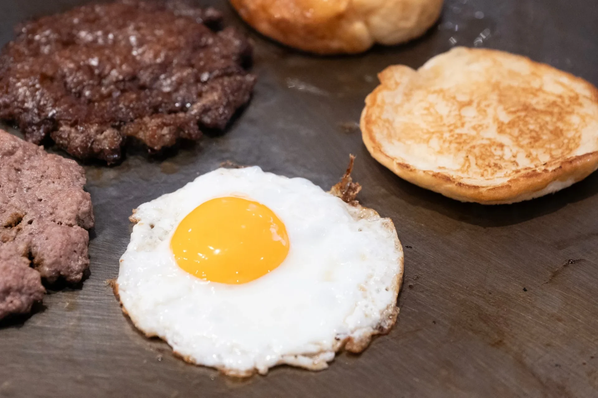 調理中のパティと目玉焼き