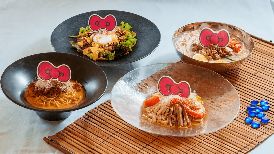 ハローキティのリボンが飾られた、パスタ、麺、サラダなど様々な種類のコラボレーションメニューが4品並んでいます。