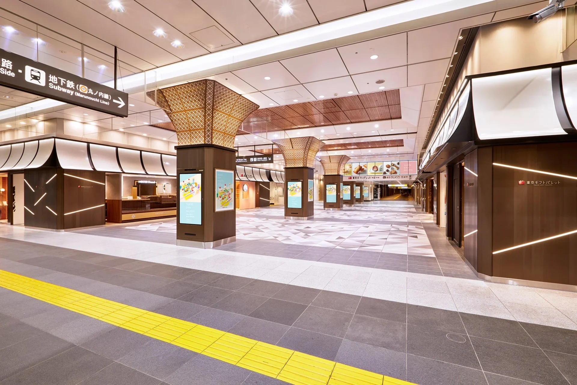東京の地下にある、明るくモダンな商業施設または駅構内の様子