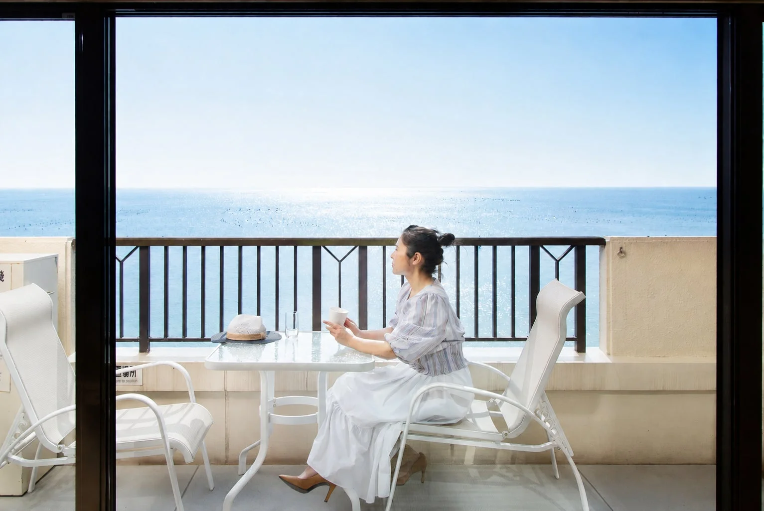 客室から海を眺める女性
