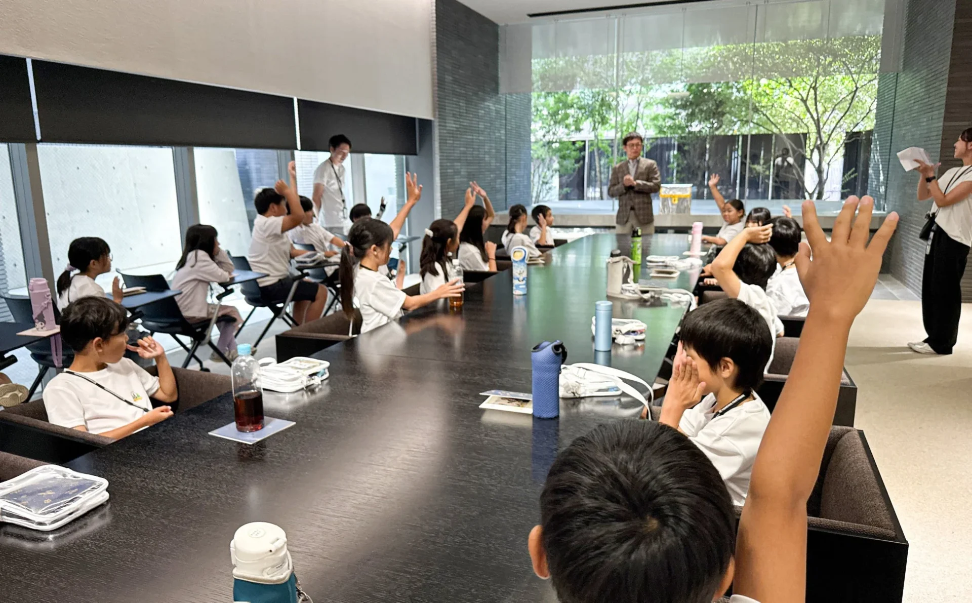 子どもたちが挙手している会議室のような風景
