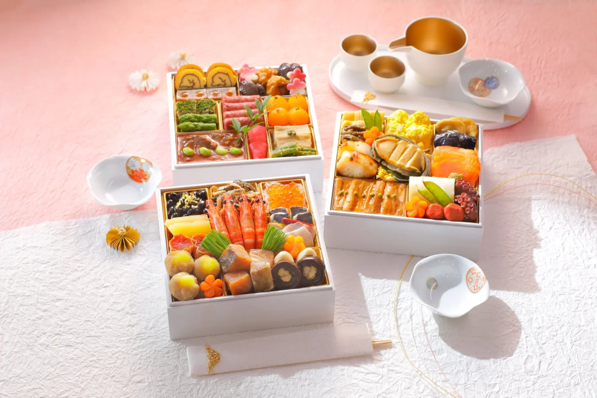 豪華な日本のおせち料理が3段の重箱に美しく盛り付けられています