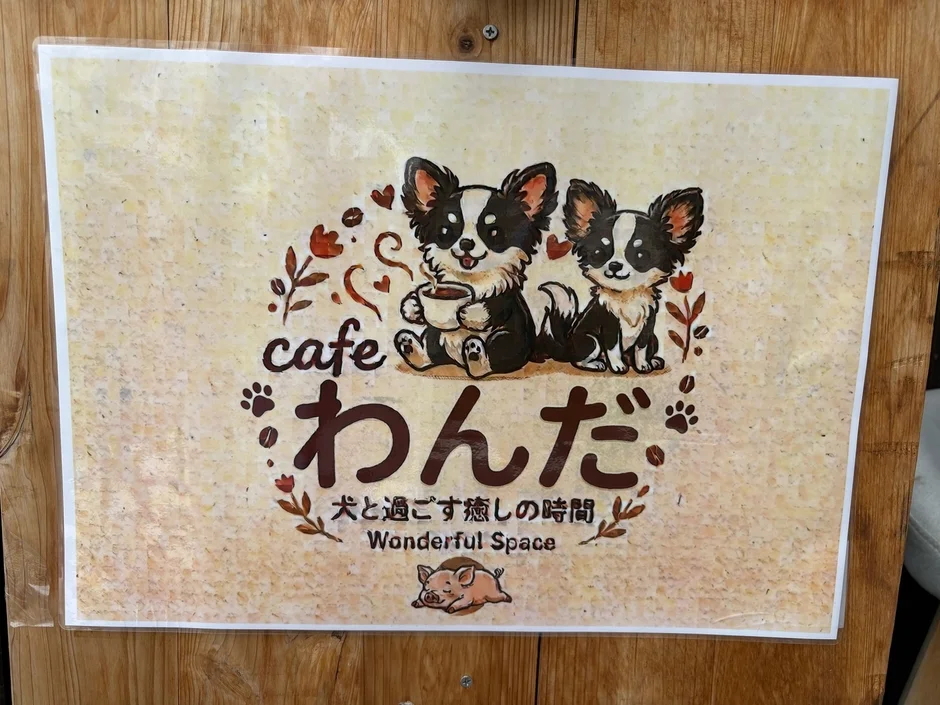 「cafe わんだ」というドッグカフェの看板です。2匹の可愛らしい犬のイラストが描かれています。