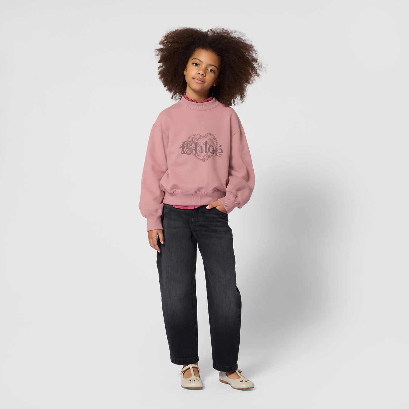 ピンクのChloéスウェットシャツを着た少女