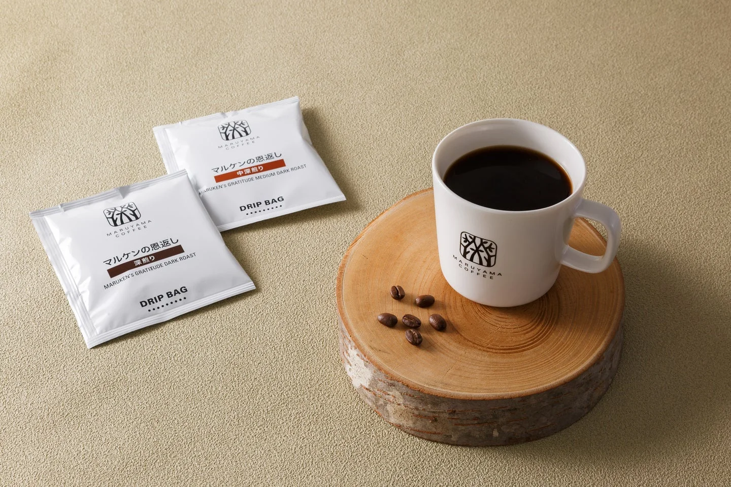 白いマグカップに入った温かいコーヒーと、その隣に2種類のドリップバッグコーヒー