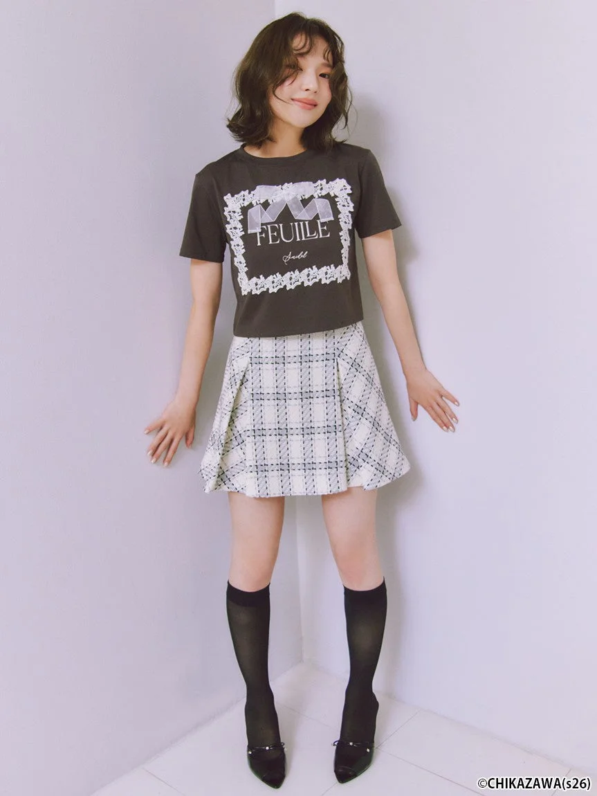 ダークグレーのTシャツに白のチェック柄プリーツミニスカートを合わせた女性モデル