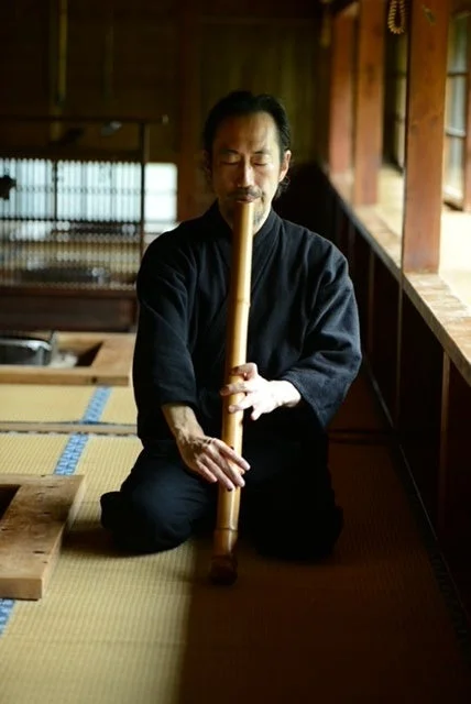 尺八を演奏する男性、日本家屋背景