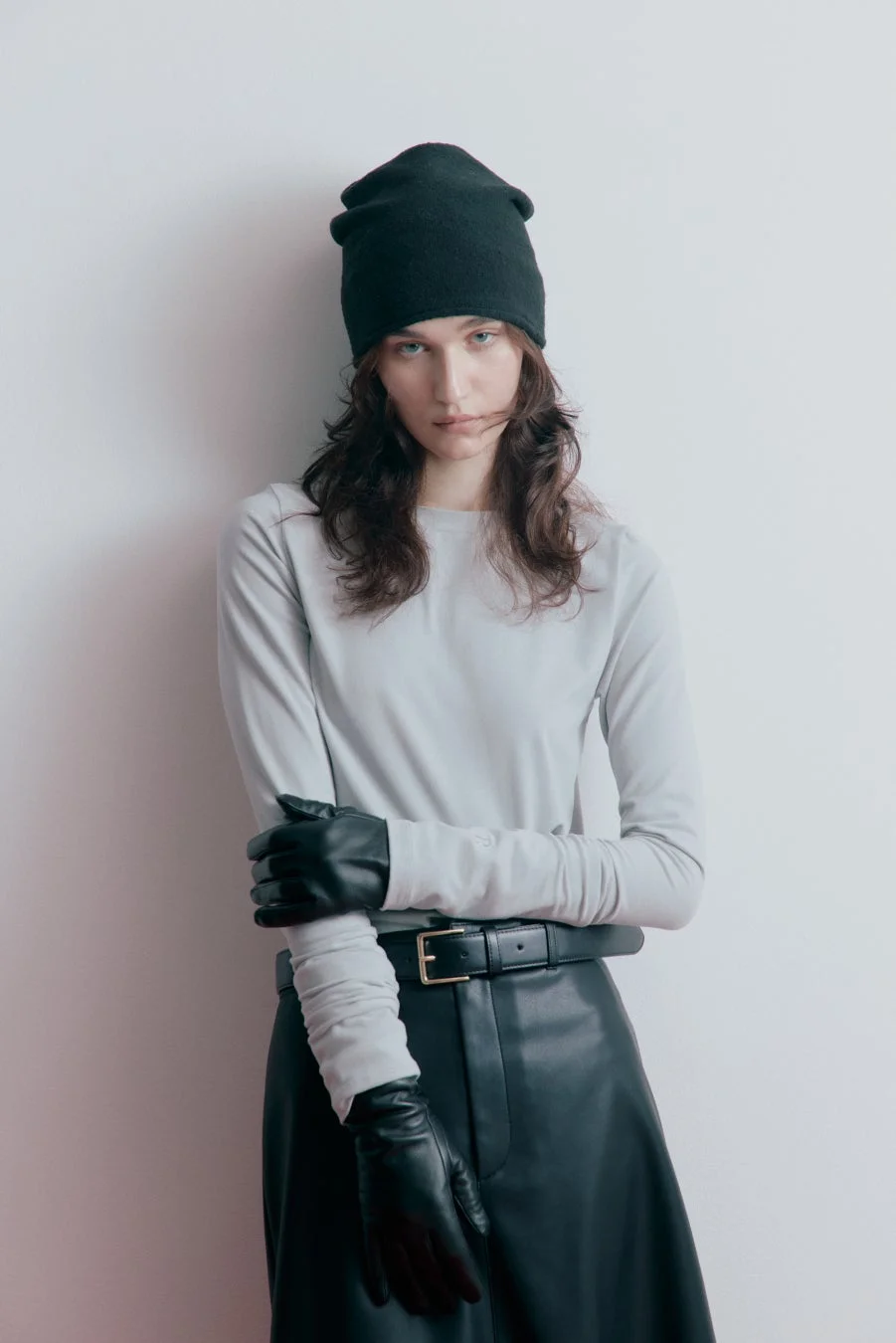 ビーニーとレザースカートの女性