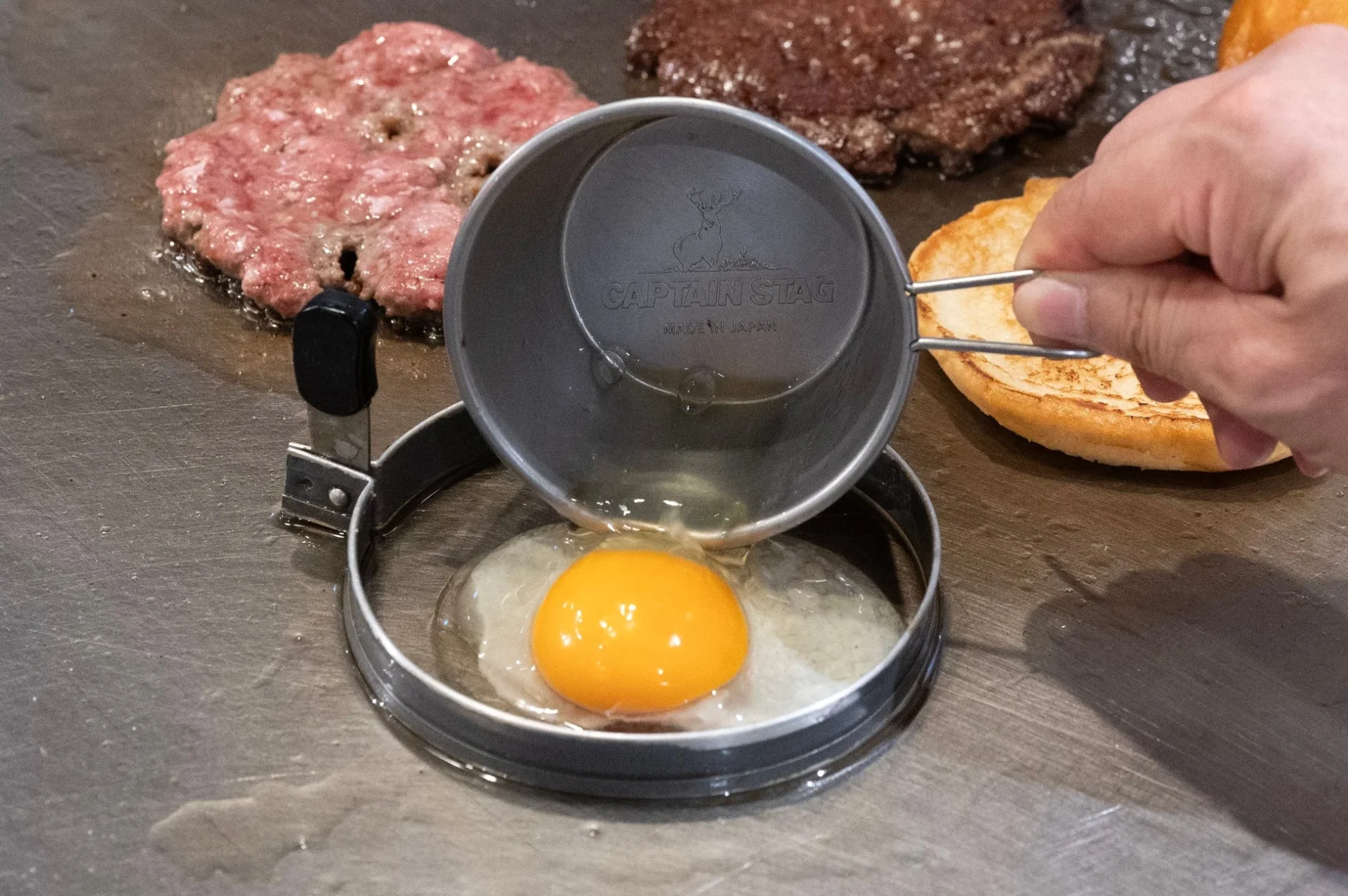 グリドルで目玉焼きとパティを調理中