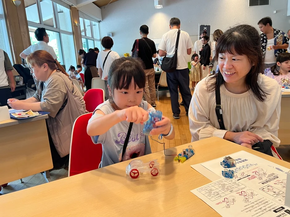 明るい室内で、親子が工作ワークショップに参加している様子