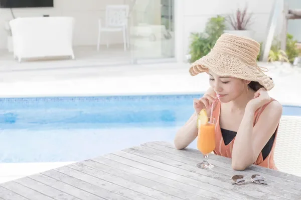 プールサイドでドリンクを飲む女性