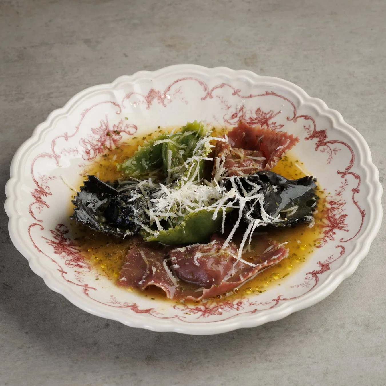 緑、黒、赤の3色のラビオリが盛り付けられた料理