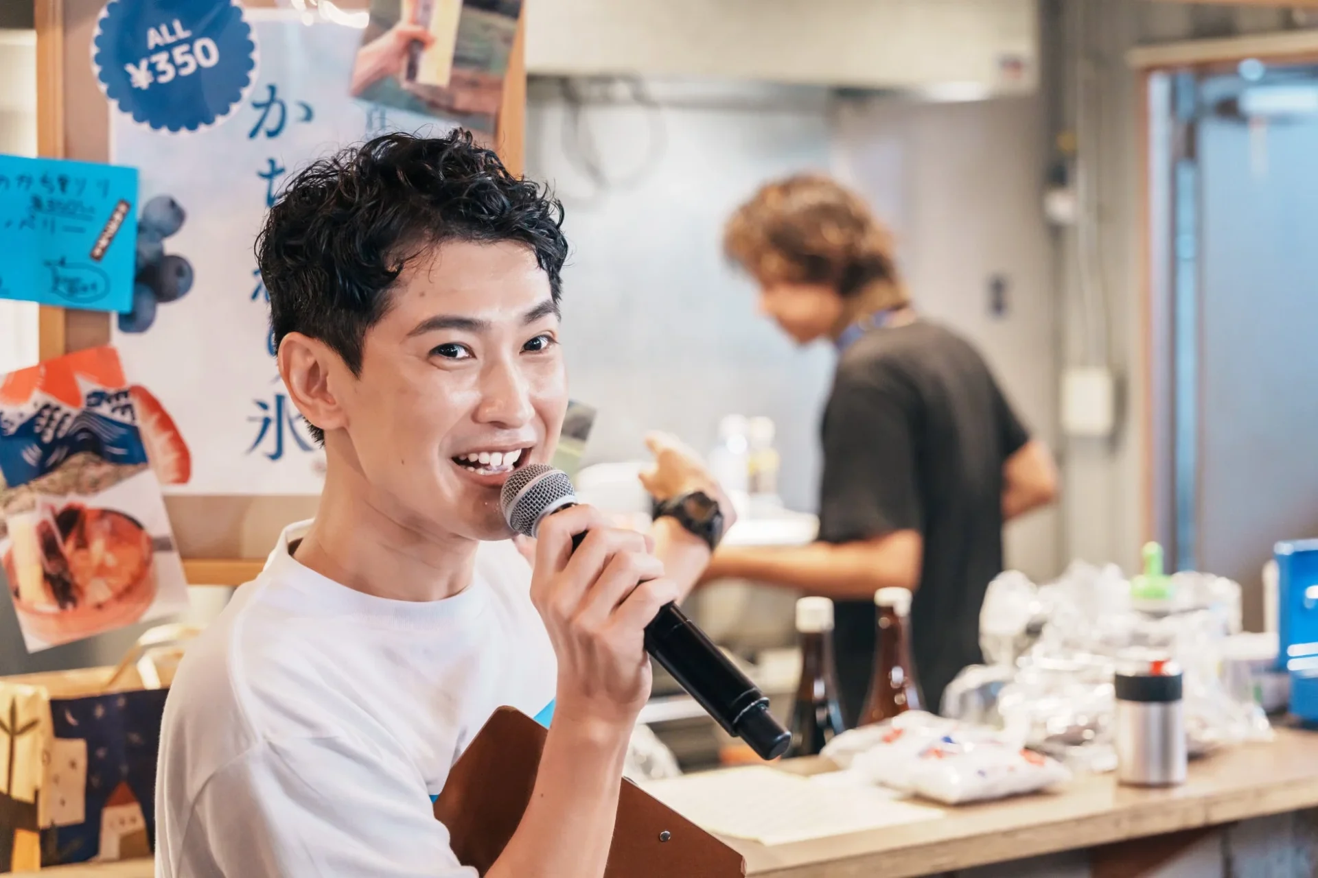 笑顔の男性がマイクを持ち、イベントを盛り上げる様子