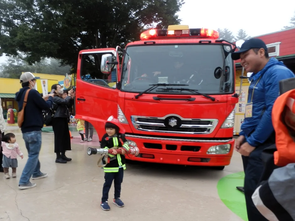 消防士の制服を着てホースを持つ子供