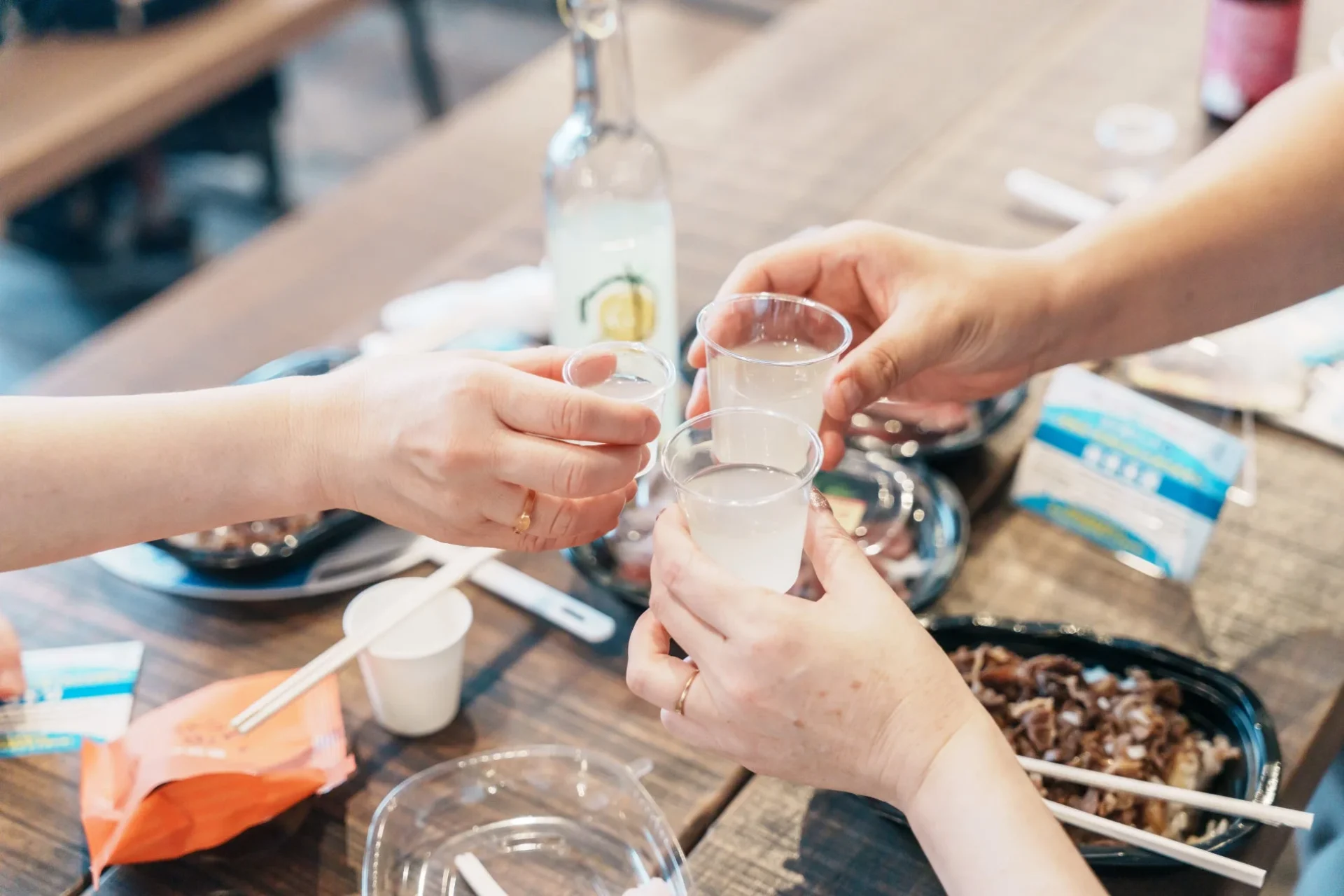 複数の人々がプラスチックカップで乾杯している様子