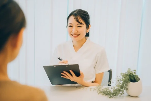 白衣の女性が顧客と対話、カウンセリング