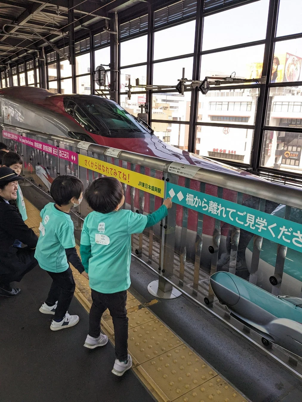 駅のホームで新幹線を見学する子供たち