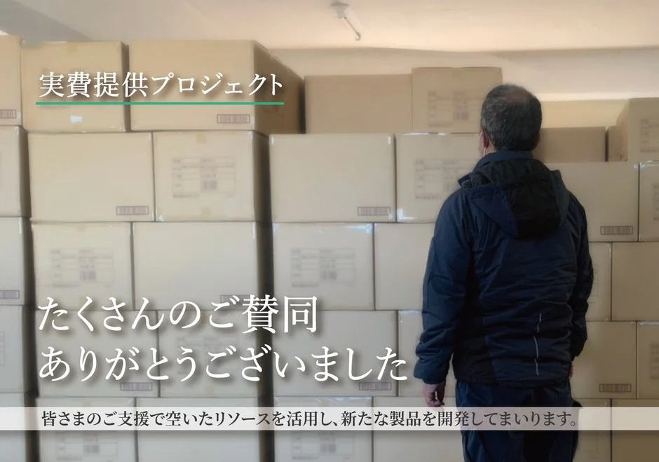 実費提供プロジェクトの感謝と新製品開発のメッセージ、男性が段ボールを見る様子