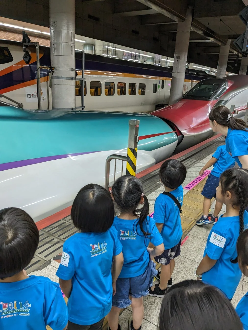 E5系とE6系の連結された新幹線を見学する子供たち