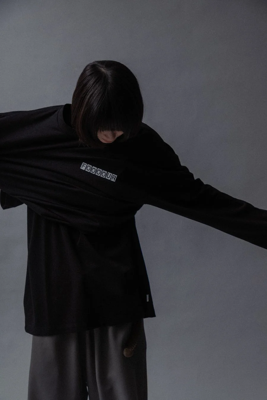 FOOOOURロゴTシャツを着た女性