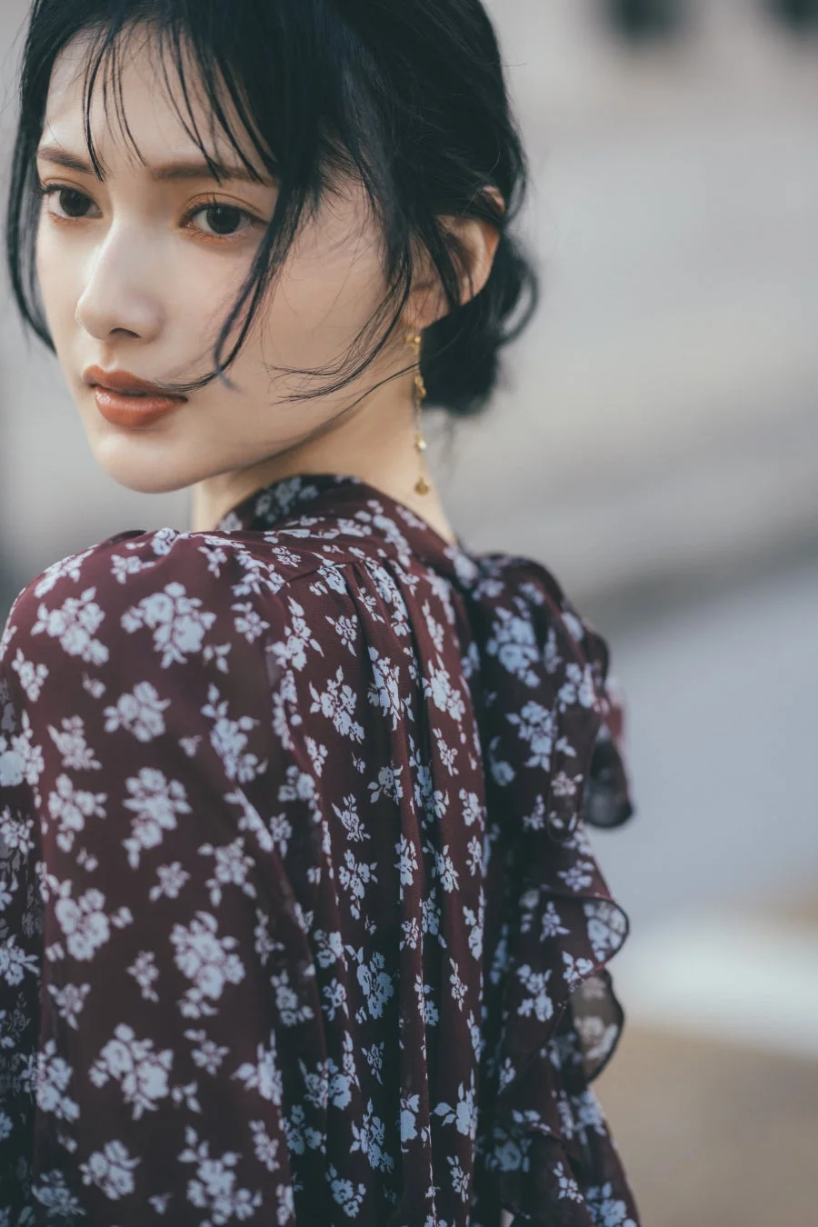 花柄のワンピースを着た黒髪の女性が振り返るポートレート