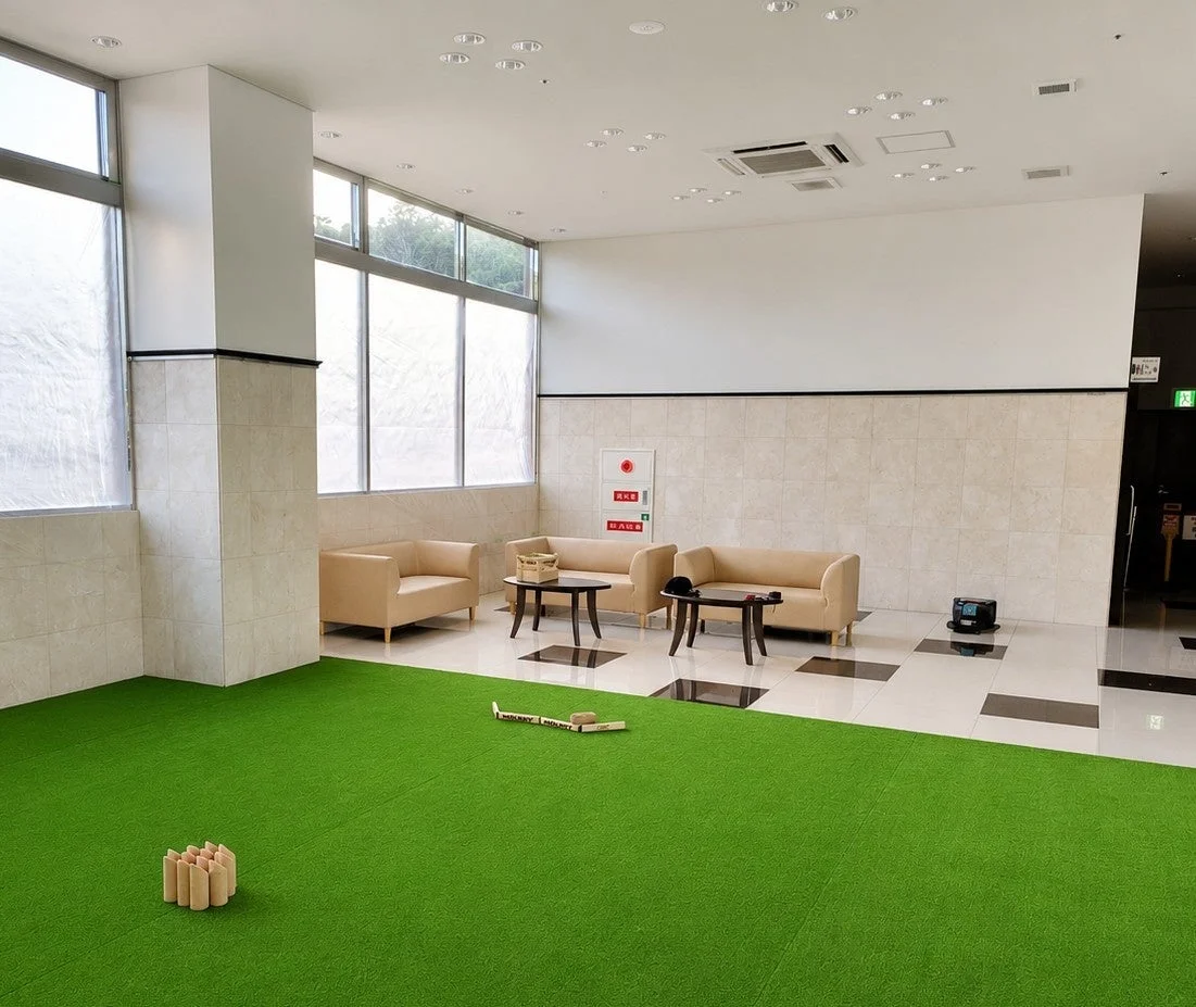 明るくモダンな屋内空間で、一部は緑のカーペットが敷かれ、モルックのゲームが楽しめるようになっています。