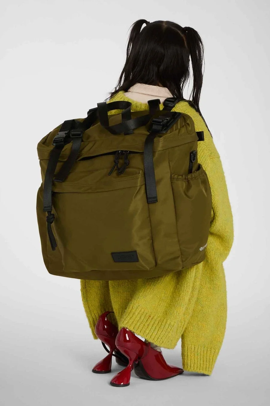 カーキのリュックを背負った女性