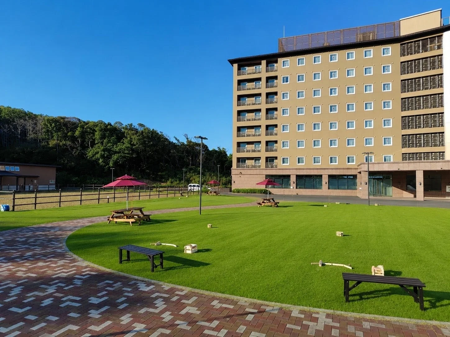 広々とした芝生が広がる庭園と、その奥に建つ大きなホテル