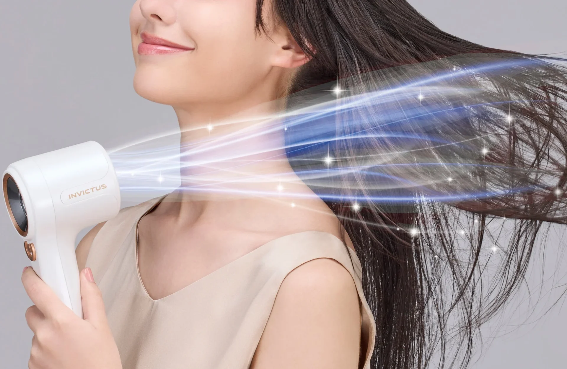 女性が白いヘアドライヤーで髪を乾かしている様子