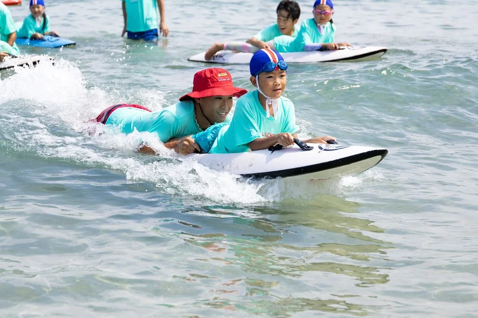 海でボードに乗る子どもたち