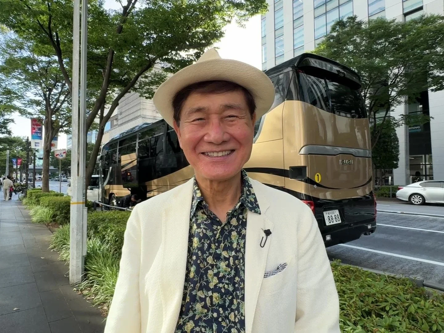 バスの前で笑顔の渡辺会長