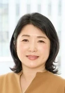 笑顔でカメラを見つめる、黒髪の日本人女性のポートレートです。