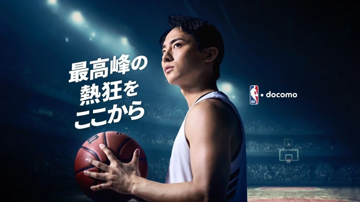 バスケットボールコートに立つ河村勇輝選手とNBA docomoのロゴ