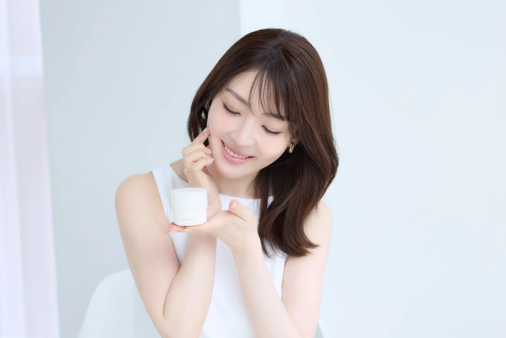 スキンケア製品を持つ女性